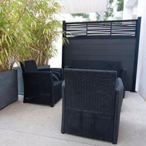 a group of wicker chairs sitting on a patio at Hotel La Ciotat - A deux pas de l'eau in La Ciotat