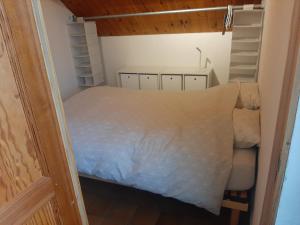 Habitación pequeña con cama y estanterías en Studio privé aux portes des Fagnes en Polleur