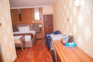 伊巴丹MAHOGANY HOTEL AND SUITES的一间带床和书桌的酒店房间