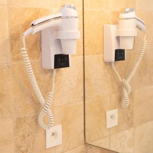 a phone hanging on a wall in a bathroom at Hotel La Ciotat - A deux pas de l'eau in La Ciotat +37 photos
