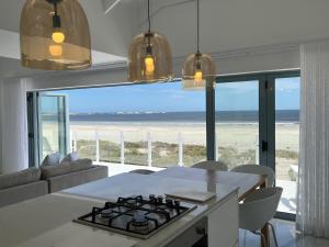 a kitchen with a view of the beach from a house at Paternoster Penthouse - Solar in Paternoster