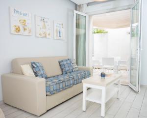a living room with a couch and a table at Hotel La Ciotat - A deux pas de l'eau in La Ciotat