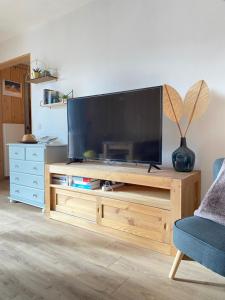 a television on a wooden entertainment center in a living room at Grand T3- pied des pistes-63 m2-8 personnes in La Toussuire