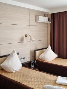 Habitación de hotel con 2 camas y almohadas blancas en Отель Бестау, en Aksay