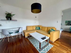 Cosy flat with huge Terrasse! Long or Shortterm في فيينا: غرفة معيشة مع أريكة وطاولة