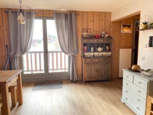 a kitchen with a large window and a refrigerator at Grand T3- pied des pistes-63 m2-8 personnes in La Toussuire