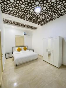 a bedroom with a bed in a white room at EK Homes in Ras al Khaimah