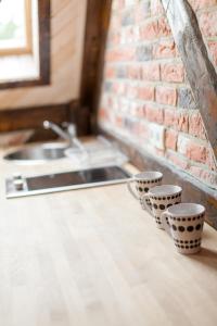 three cups sitting on a counter next to a sink at Gospodarstwo Agroturystyczne Kowalowe Wzgórze in Polanica-Zdrój