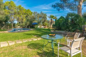 a patio with a table and chairs and a pool at Garriga d'Alcudiola in Santa Margalida