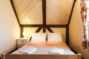 a bed in a room with a wooden ceiling at Gospodarstwo Agroturystyczne Kowalowe Wzgórze in Polanica-Zdrój