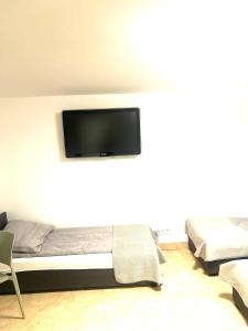 Habitación con cama y TV de pantalla plana en la pared. en Hostel 24 Miejsca Parkingowe Noclegi Pracownicze., en Gorzów Wielkopolski