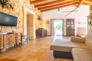 a living room with a couch and a tv at Garriga d'Alcudiola in Santa Margalida