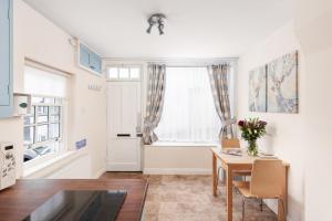 a living room with a table and a window at Bluegrass Cottage - Free parking in Whitby