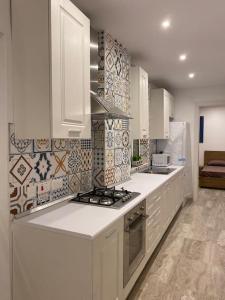 a kitchen with white cabinets and a stove top oven at Beach House. Live, experience sea in St. Paul's Bay