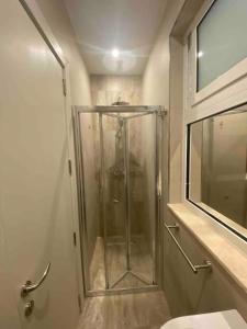 een douche in een badkamer met een glazen douchecabine bij Beach House. Live, experience sea in St Paul's Bay