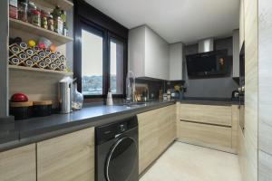 a kitchen with a black dishwasher and wooden cabinets at Atico Gran Sol in Rincón de la Victoria