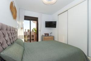 a bedroom with a green bed and a couch at Atico Gran Sol in Rincón de la Victoria