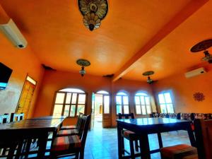 a dining room with orange walls and tables and chairs at Riad family in Merzouga