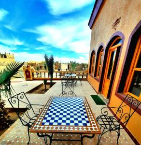 a checkered table and chairs on a patio at Riad family in Merzouga