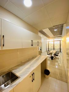 a kitchen with white cabinets and a table and chairs at EK Homes in Ras al Khaimah +116 photos