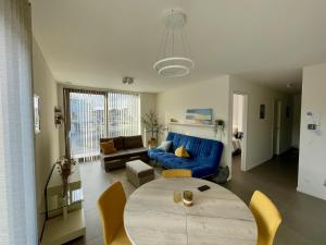 a living room with a blue couch and a table at West Bay Apartments in Middelkerke