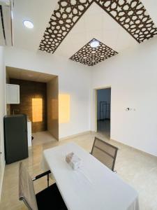 a dining room with a white table and chairs at EK Homes in Ras al Khaimah