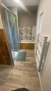 a bathroom with a shower and a tiled floor at Chambre chez Audrey in Saligny-sur-Roudon