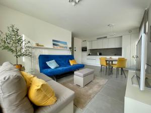 a living room with a blue couch and a kitchen at West Bay Apartments in Middelkerke