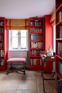 a room with red walls and a window and a bench at Bert's - your idyllic Derbyshire retreat in Bonsall