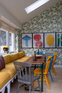 uma sala de estar com um sofá, uma mesa e cadeiras em Bert's - your idyllic Derbyshire retreat em Bonsall