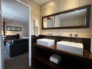 La salle de bains est pourvue de 2 lavabos et d'un miroir. dans l'établissement Domaine de Saint-Paul, à Saint-Rémy-lès-Chevreuse