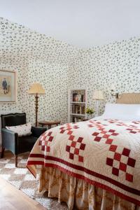 a bedroom with a red and white bed and a chair at Bert's - your idyllic Derbyshire retreat in Bonsall