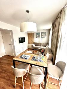 a living room with a table and chairs and a couch at Jantaris B1 - Apartament 20m od plaży in Mielno