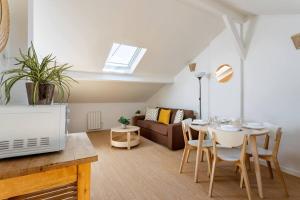 a living room with a table and a couch at Au bord du canal G *Paris*Disney*Gare* in Chelles