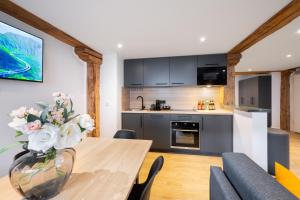 eine Küche und ein Esszimmer mit Tisch und Stühlen in der Unterkunft Homaris Apartments München Laim in München
