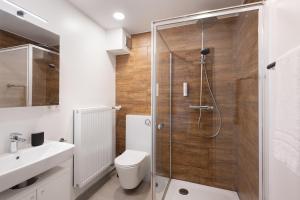 ein Badezimmer mit Dusche, Toilette und Waschbecken in der Unterkunft Homaris Apartments München Laim in München + 37 Fotos