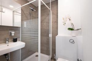 ein Badezimmer mit Dusche und Waschbecken in der Unterkunft Homaris Apartments München Laim in München