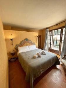 een slaapkamer met een groot bed en een groot raam bij SATUNA CASA TÍPICA MAR in Begur