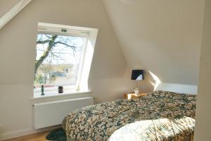 1 dormitorio con cama y ventana en Ferienhaus Auszeit auf dem Berghof, en Tastrup