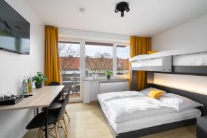 a bedroom with a bed and a desk and a table at Homaris Apartments München Laim in Munich