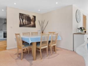 a dining room with a blue table and chairs at Ash Tree Cottage in Bosherston