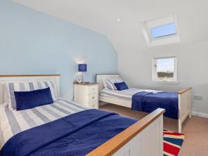 a bedroom with two beds and a window at Ash Tree Cottage in Bosherston