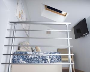 a shelf in a room with a tv at Hotel La Ciotat - A deux pas de l'eau in La Ciotat