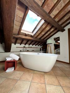 un bagno con grande vasca bianca e lucernario. di Santa Cecilia Perugia - Rooms&Suite a Perugia