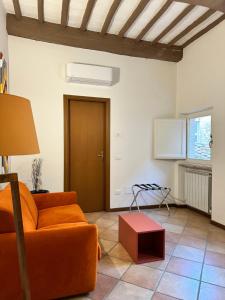 sala de estar con sofá naranja y mesa en Santa Cecilia Perugia - Rooms&Suite, en Perugia