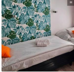 1 cama en un dormitorio con una pared floral en Centrum Wellness Hostel, en Debrecen