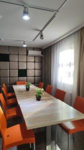 una sala de conferencias con mesa de madera y sillas naranjas en Отель Бестау, en Aksay