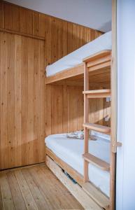 2 Etagenbetten in einem Zimmer mit Holzwänden in der Unterkunft hejHUS w Strzyżach 
