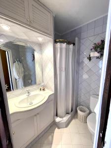 een witte badkamer met een wastafel en een douche bij SATUNA CASA TÍPICA MAR in Begur