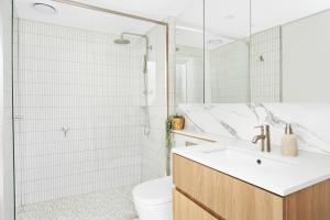 a white bathroom with a sink and a toilet at Kashmir, Modern and luxury 2BR 2BA, Fast WiFi & Netflix, Free Parking, Central Location, near CBD in Canberra